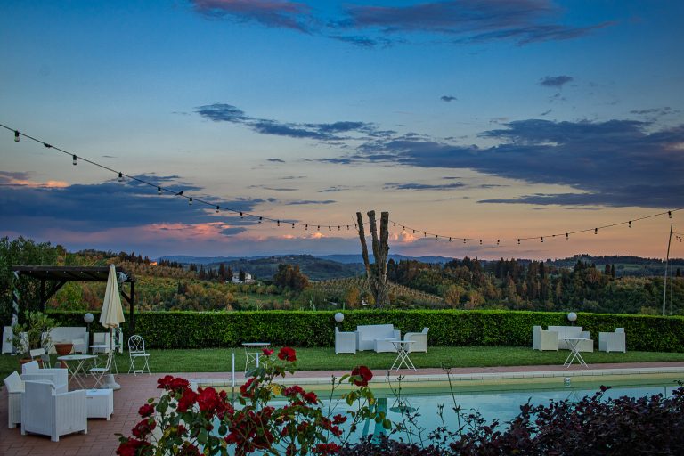 tring lights and scattered clouds frame a peaceful Tuscan landscape at golden hour. Photographed from a hilltop agriturismo near San Gimignano.